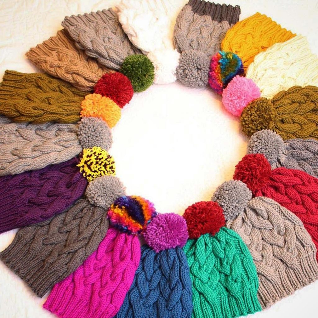 Circle of knit cabled hats all in different colors