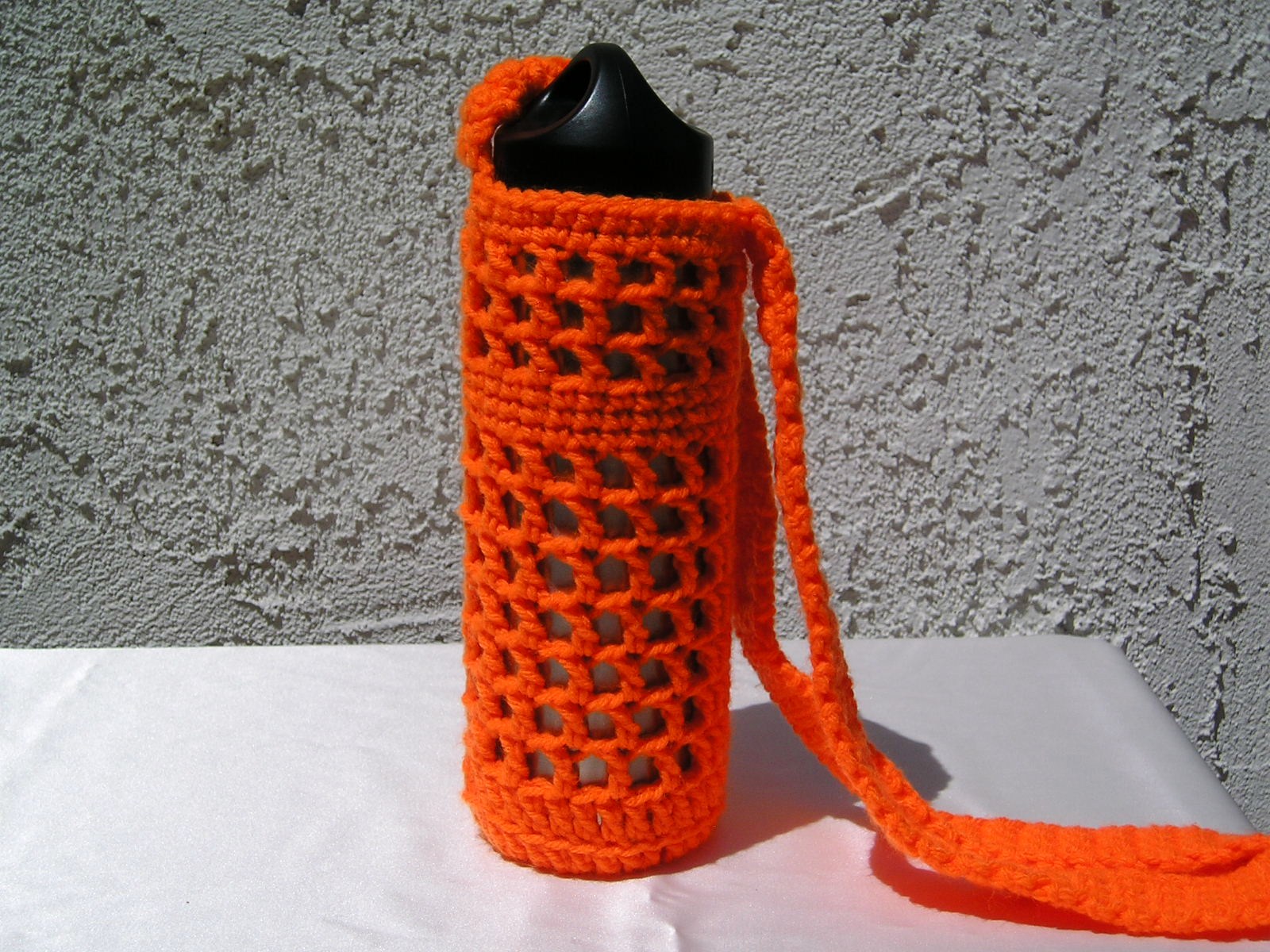 bright orange crocheted bag with water bottle inside