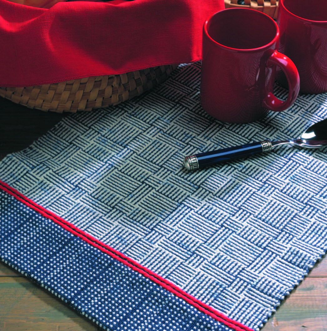 woven table runner in a navy and white cross hatch pattern accented by a bright red stripe 