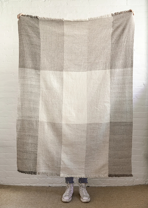large woven cabin blanket featuring blocks in natural shades of taupe, cream, and grey