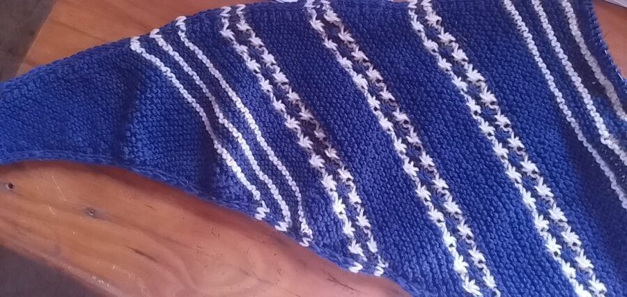 The first clue of the True Blue shawl in blue and white on a table