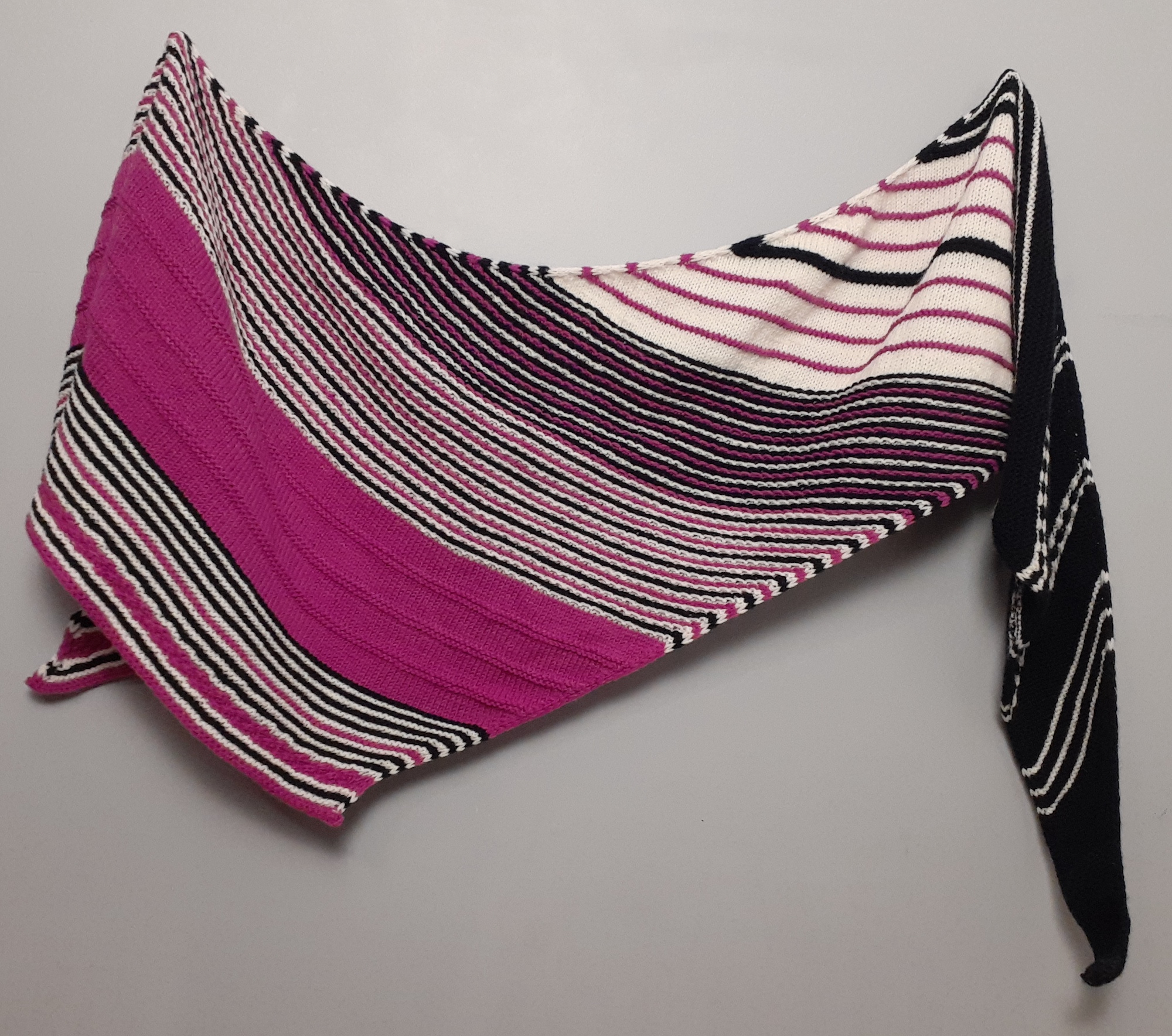 Tonia Lyons True Blue Shawl in hot pink, navy blue and cream hanging on a gray wall