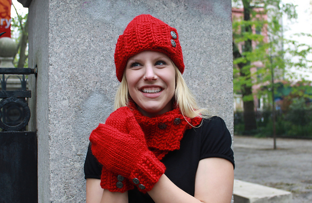 Smiling blonde woman wears handknit matching sest of hat, mittens, and cowl