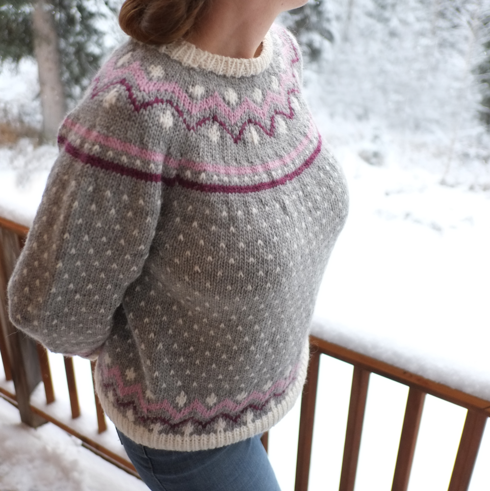 The Rose Frost Sweater seen in grey with white speckles and pink and maroon colorwork details