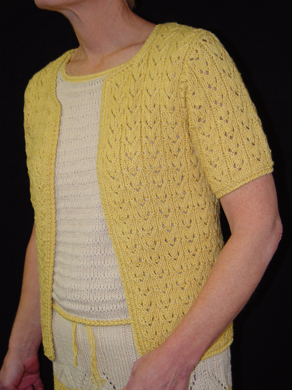 a lemon yellow knit lace short sleeve cardigan worn over a knit outfit