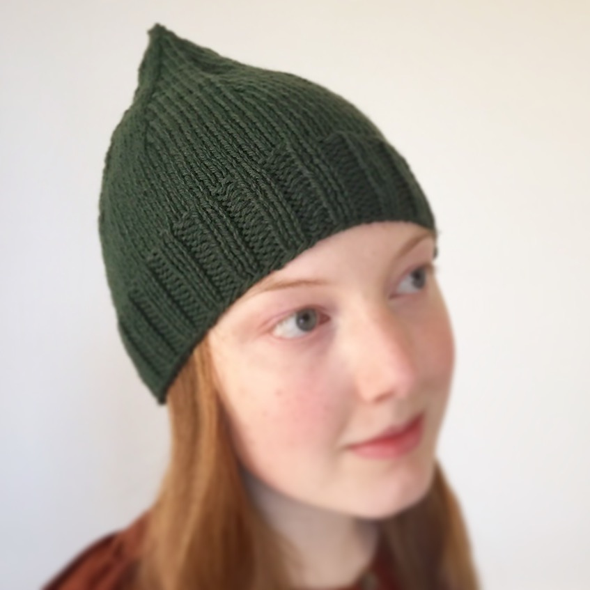 Pure wool hat knit in evergreen color on redheaded girl